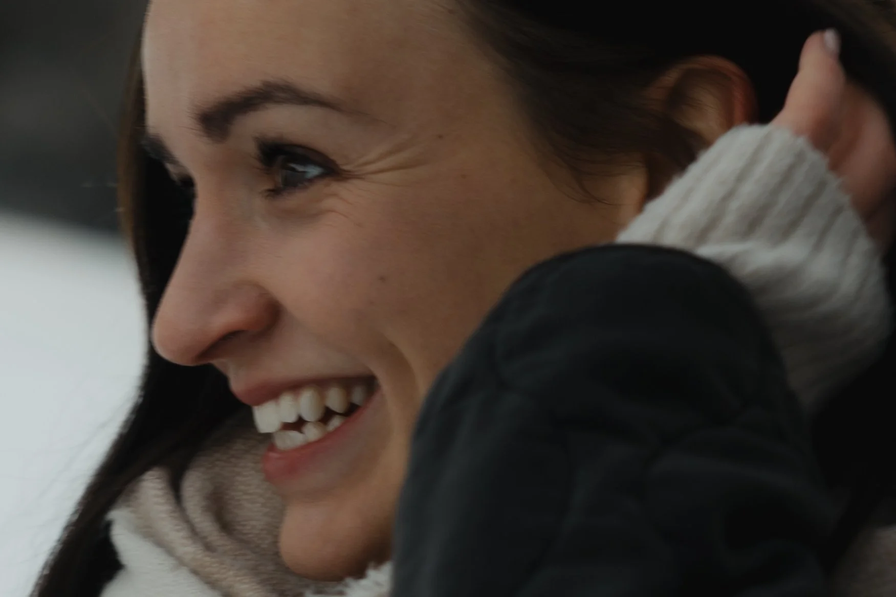 Nahaufnahme eines lachenden jungen Mädchens mit braunen Haaren. Modernes Familienshooting mit Pia Heim im Winter.