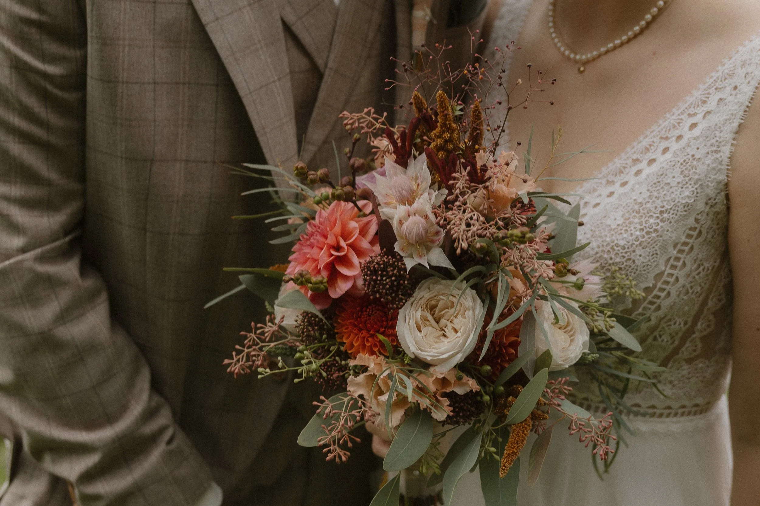 Nahaufnahme eines Brautpaars mit Brautstrauß bei einer Hochzeit, nur Oberkörper sichtbar