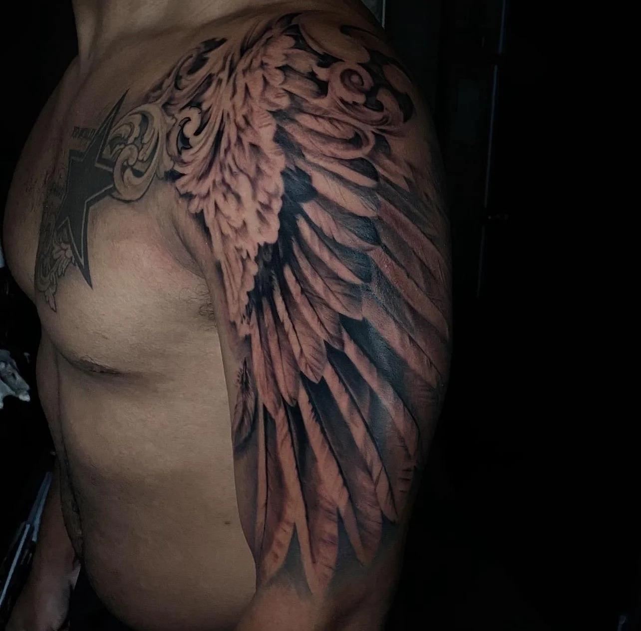 Tattoo of a detailed eagle with spread wings on a person's shoulder and upper arm.