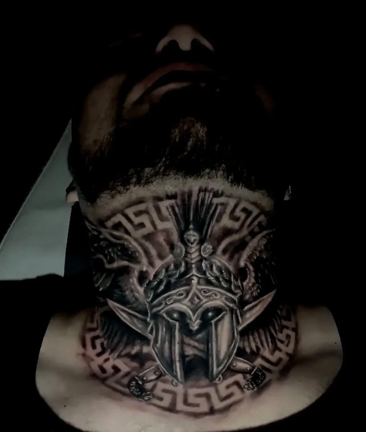 A close-up of a person's neck tattoo featuring a fierce lion's head with a crown, surrounded by geometric tribal patterns.