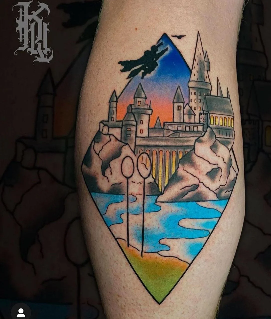 Colorful tattoo of a fantasy castle on rocky cliffs, with a lake and mountains in the background, within an diamond-shaped outline.