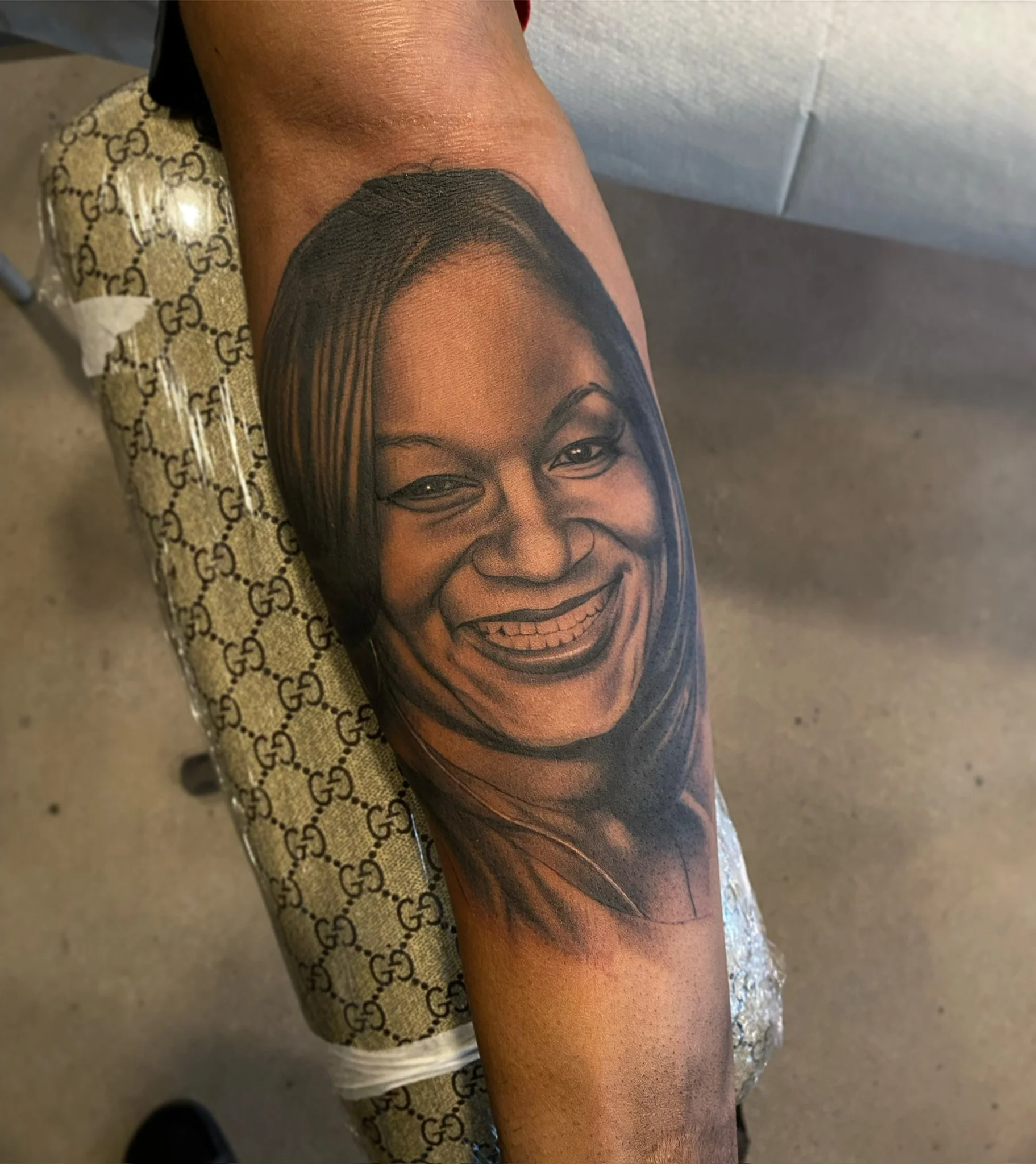 Tattoo of a woman's smiling face on a person's arm.