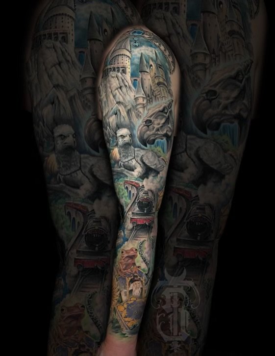 Colorful tattoo sleeve featuring a fantasy landscape, including castles, mountains, lions, a train, and other detailed elements.