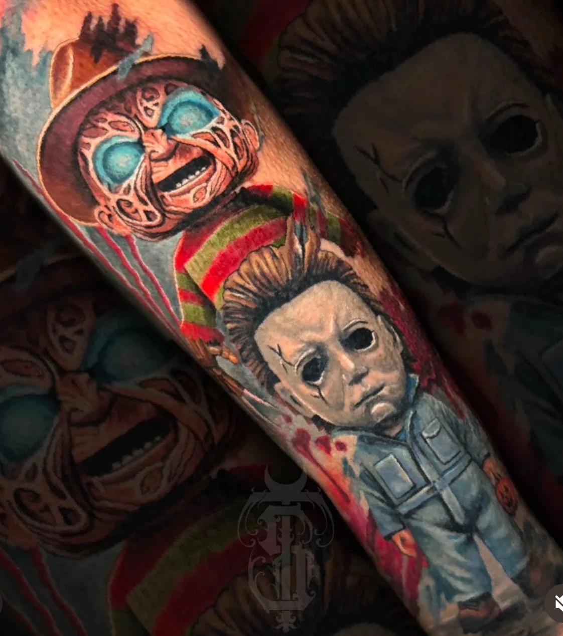 Close-up of tattoos on a person's arm, including a portrait of Michael Myers from Halloween, and a clown with bright blue eyes and an angry expression.