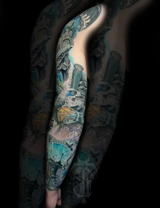 Close-up of a person's arm and side with detailed, colorful tattoos including dollar bills, a lighthouse, and various designs.