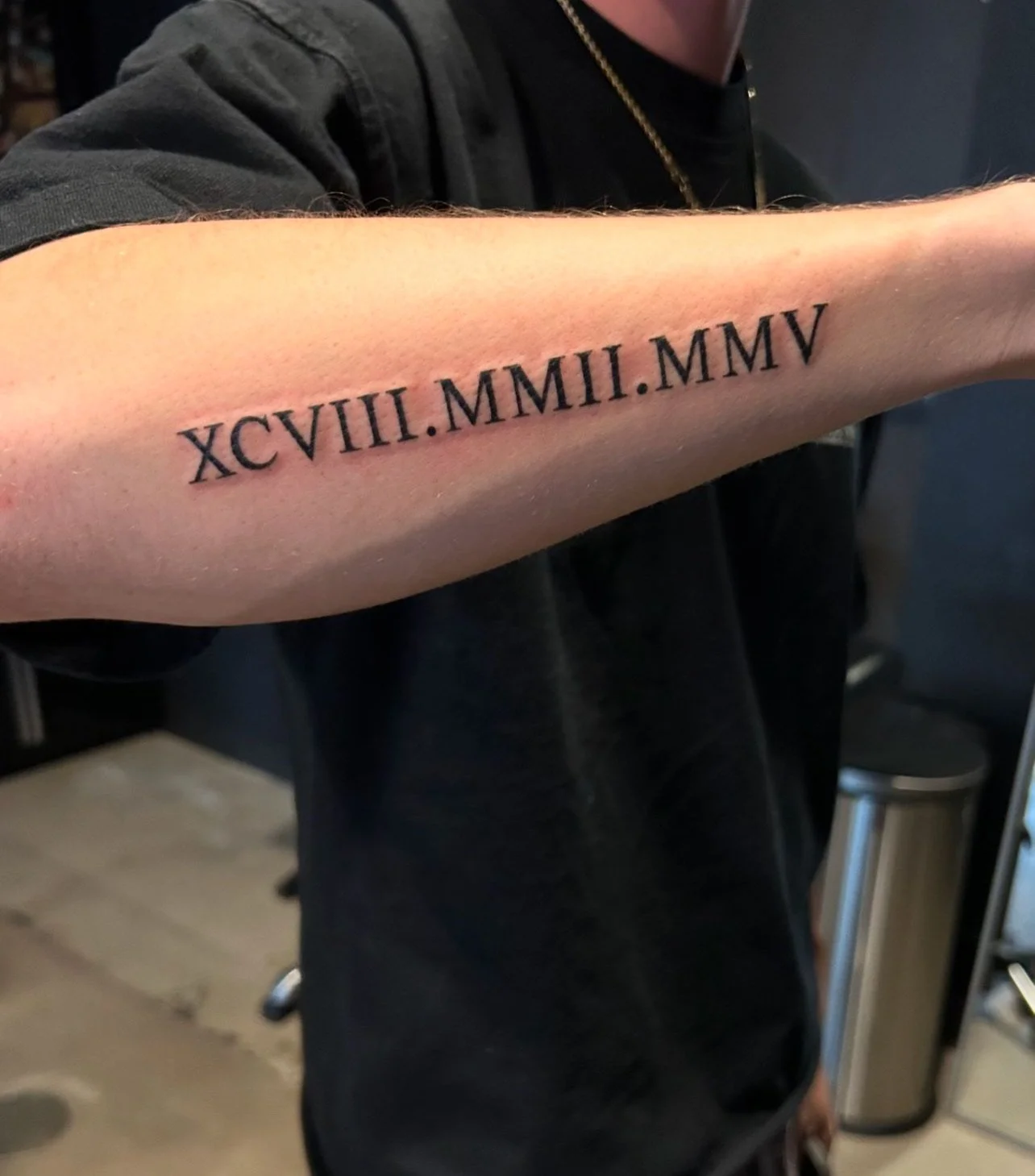 Tattoo of Roman numerals on person's forearm.