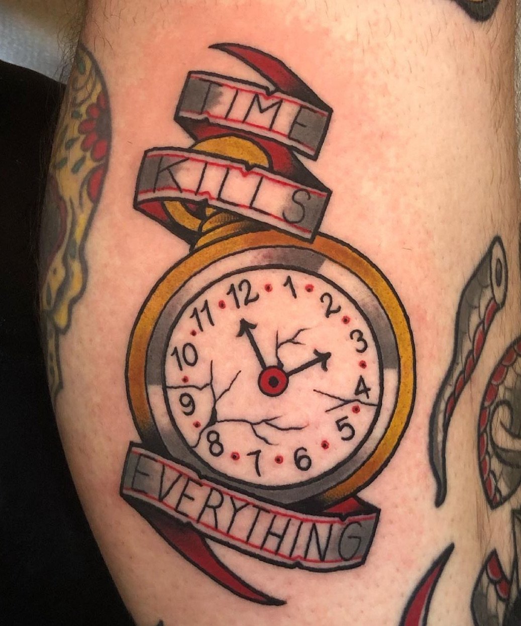 A tattoo of a cracked pocket watch with the words "Time is everything" above and below the watch. The watch shows the time as 2:55 and 11:55.