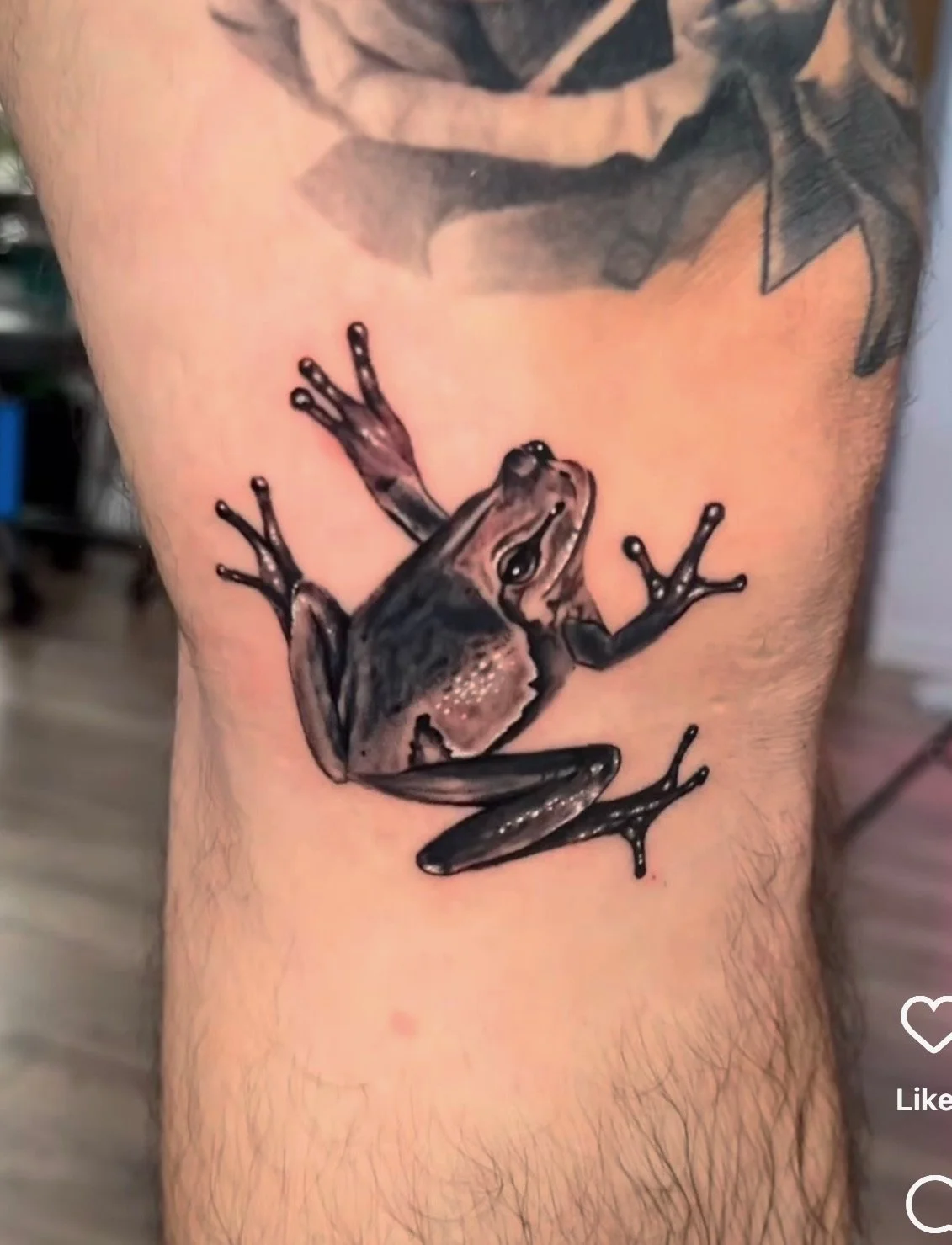 Tattoo of a frog climbing on a person's skin, depicting detailed shading and realistic features.