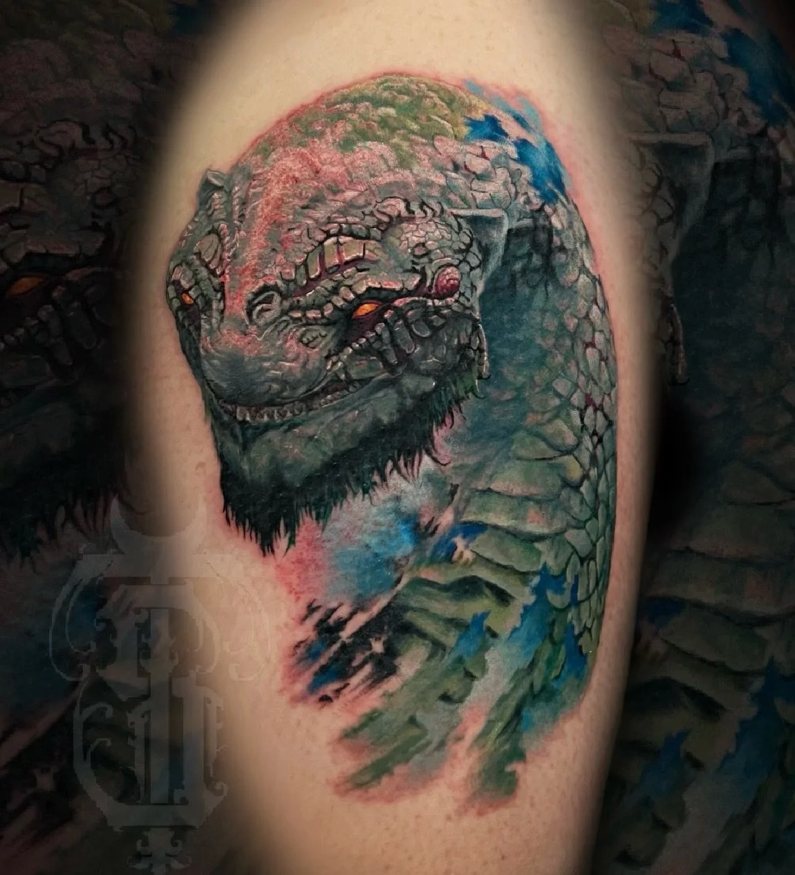 Tattoo of a dragon's face with scales, claws, and eyes on a person's arm.