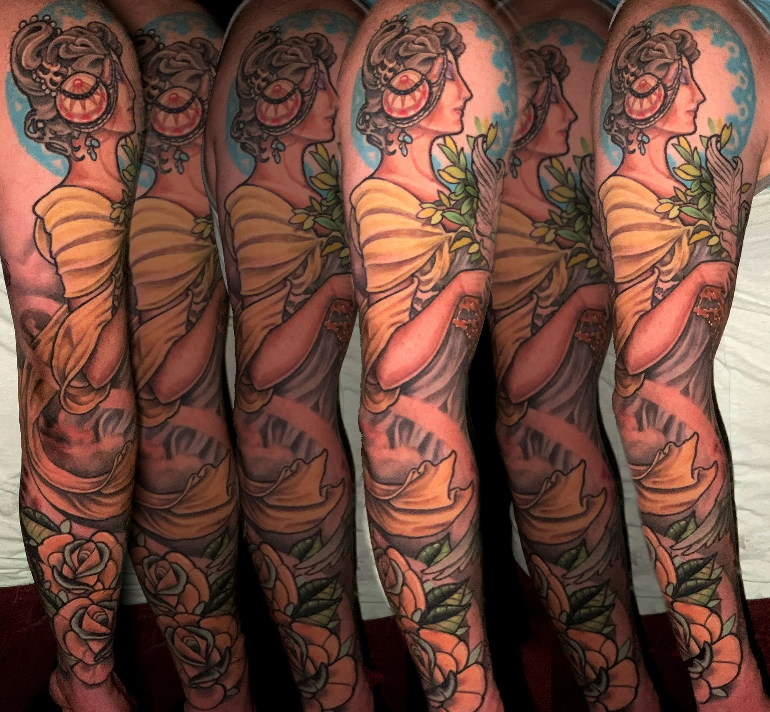 Close-up of multiple tattooed arms featuring colorful, detailed designs, including a prominent profile of a woman with curly hair, large earrings, yellow clothing, flowers, and green leaves.