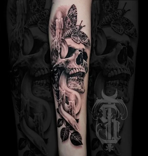 A tattoo sleeve featuring a skull, a snake, a butterfly, and leaves in black and gray ink.