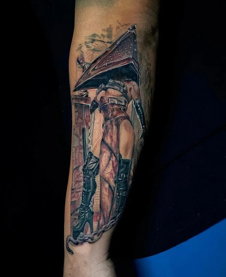 Tattoo of a woman in combat gear, holding a large shield and sword, with chain and dagger, on arm.