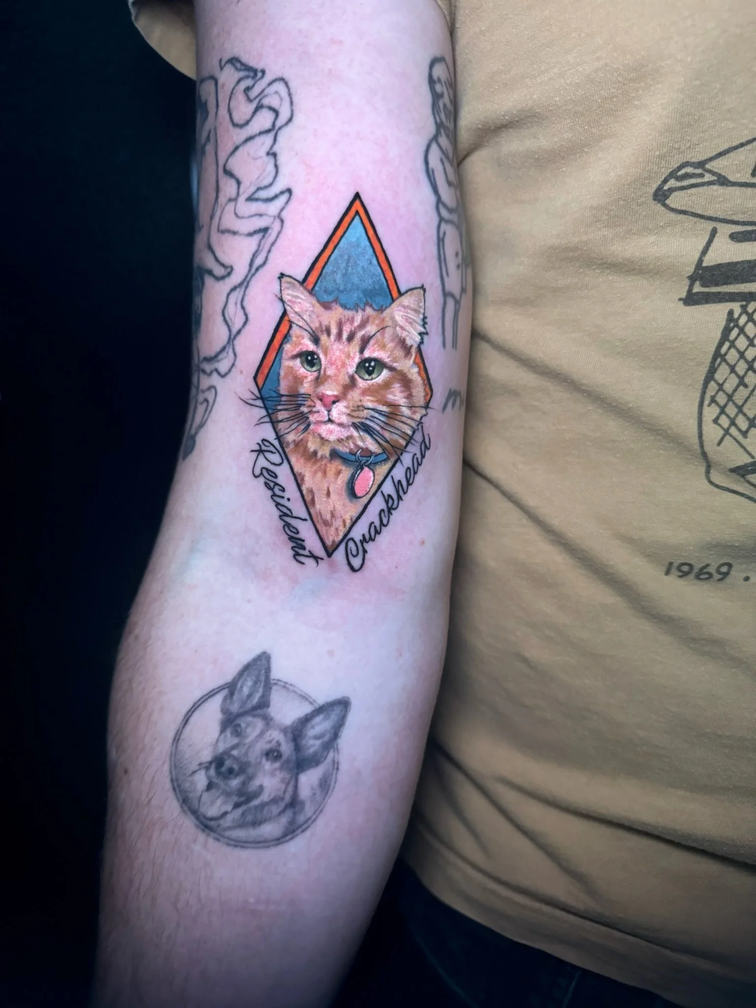 Tattoo of a leopard cat with the names 'Mershby' and 'Crackhead' written in cursive, with a background of geometric shapes.