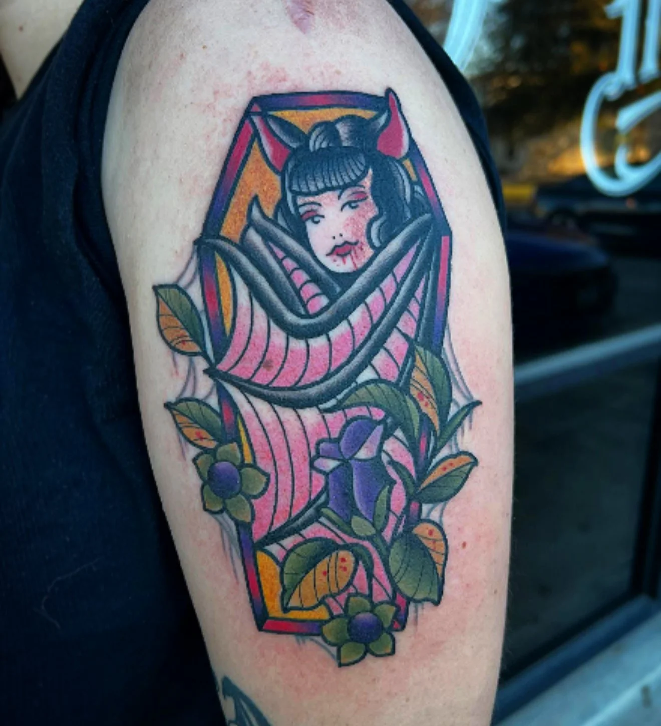 tattoo of a vampire bat girl inside of a coffin with rose flowers on bicep