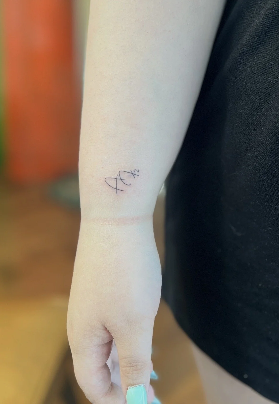 small initial on wrist tattoo