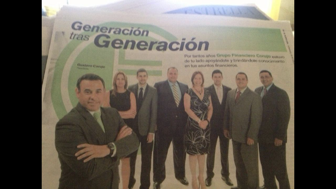Group of eight professionals, six men and two women, standing together in formal attire, with a financial group banner in the background.