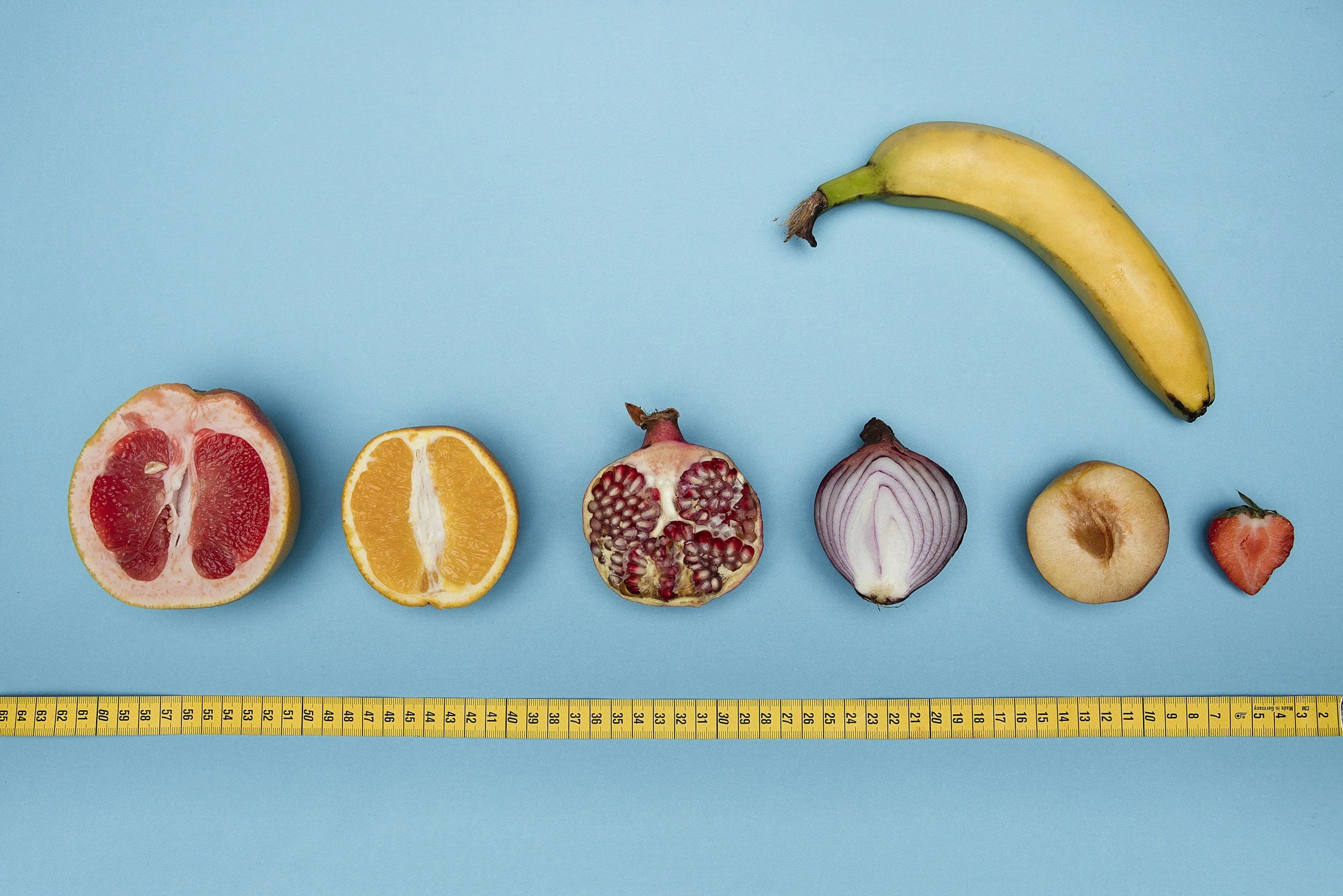 Fruits and vegetables on blue background next to yellow ruler