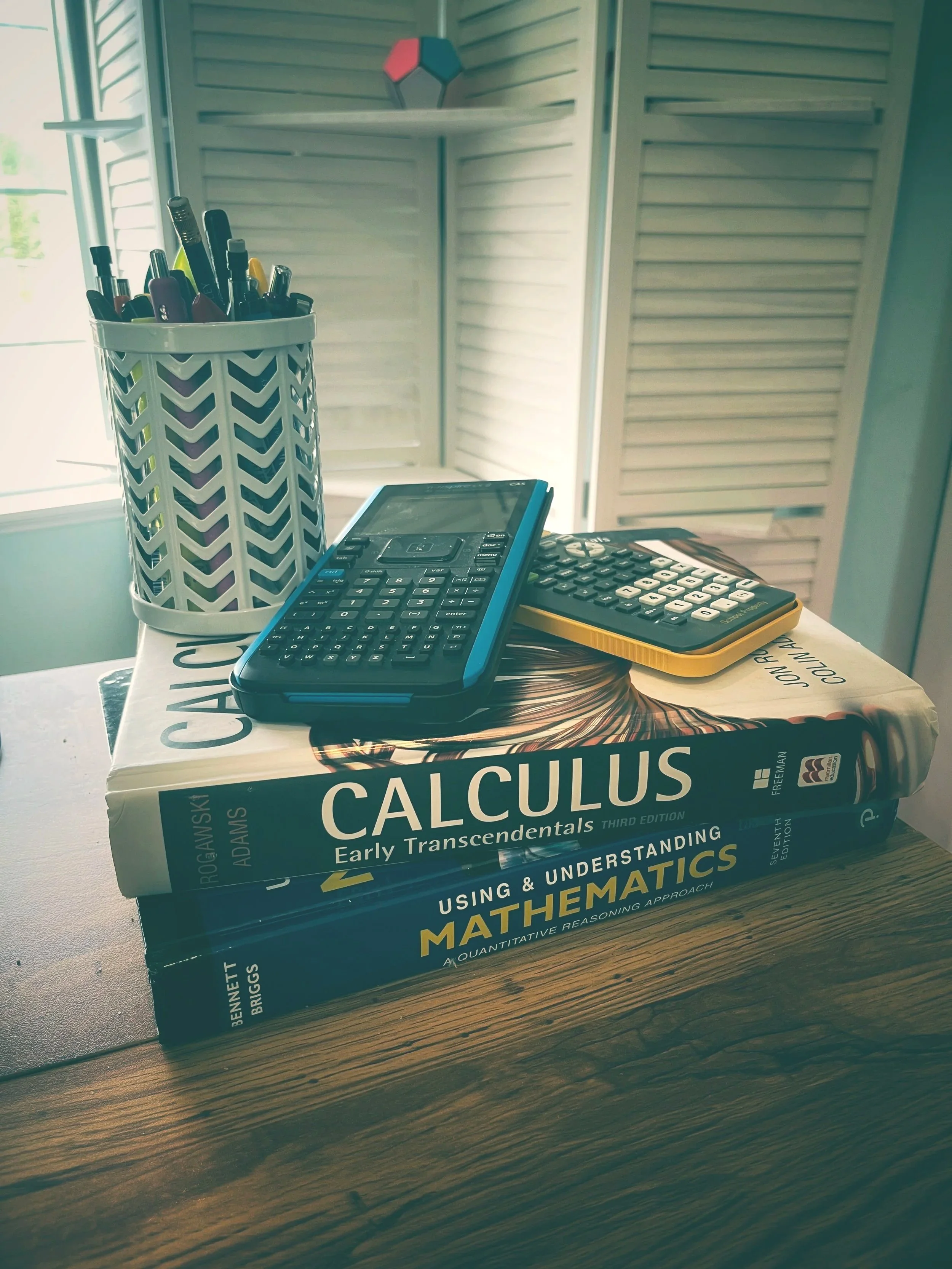 Two math textbooks with two calculators on top