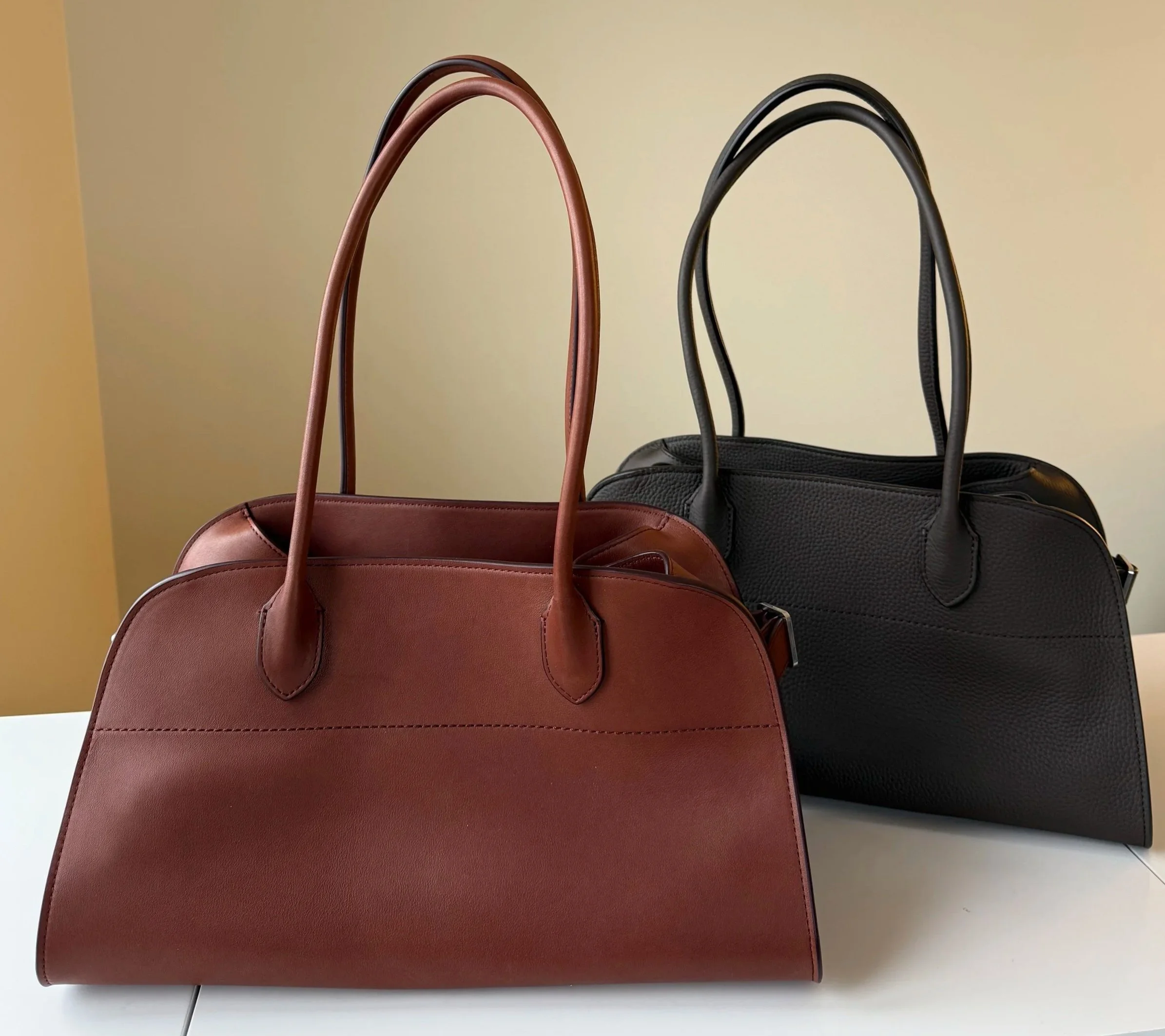 Front view comparison of the polished vs. grained leather finishes of the Row Margaux Shoulder 12