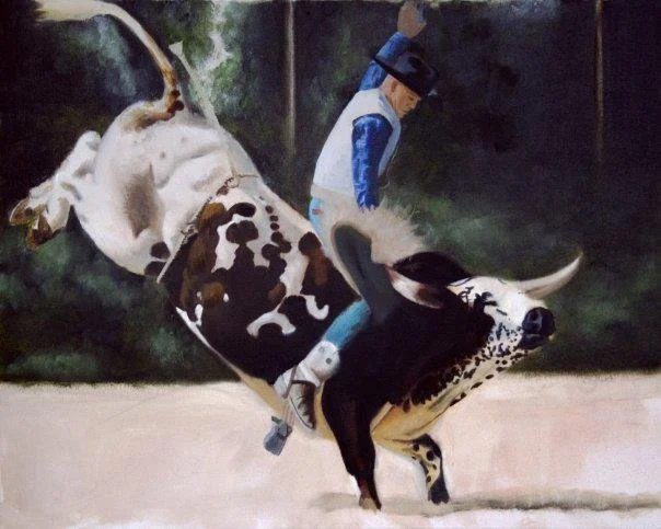 A man wearing a blue jacket and cap is riding a black and white dog in a playful dog race, with the dog tilting and moving quickly on a sandy track.