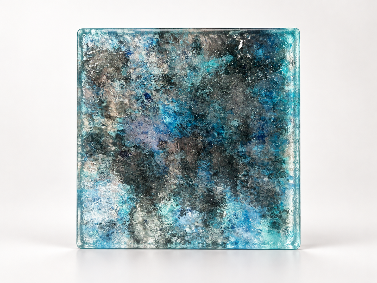 Azure custom kiln-formed architectural glass slab with layered blue, turquoise, and charcoal colors and textured surface.