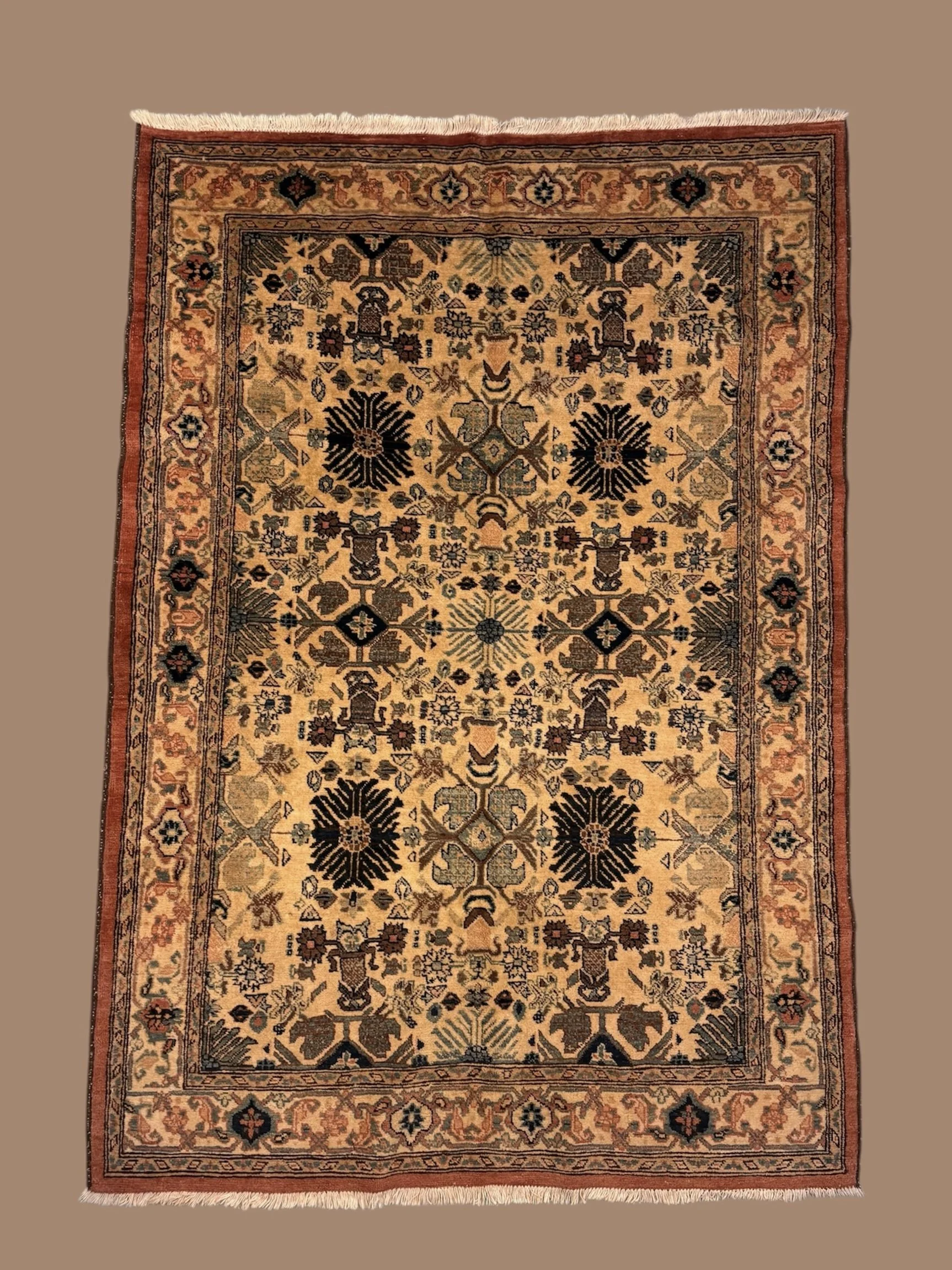 A traditional Persian-style area rug with intricate floral and geometric patterns in black, red, beige, and green colors, bordered by multiple decorative borders, with fringes on the top and bottom edges.