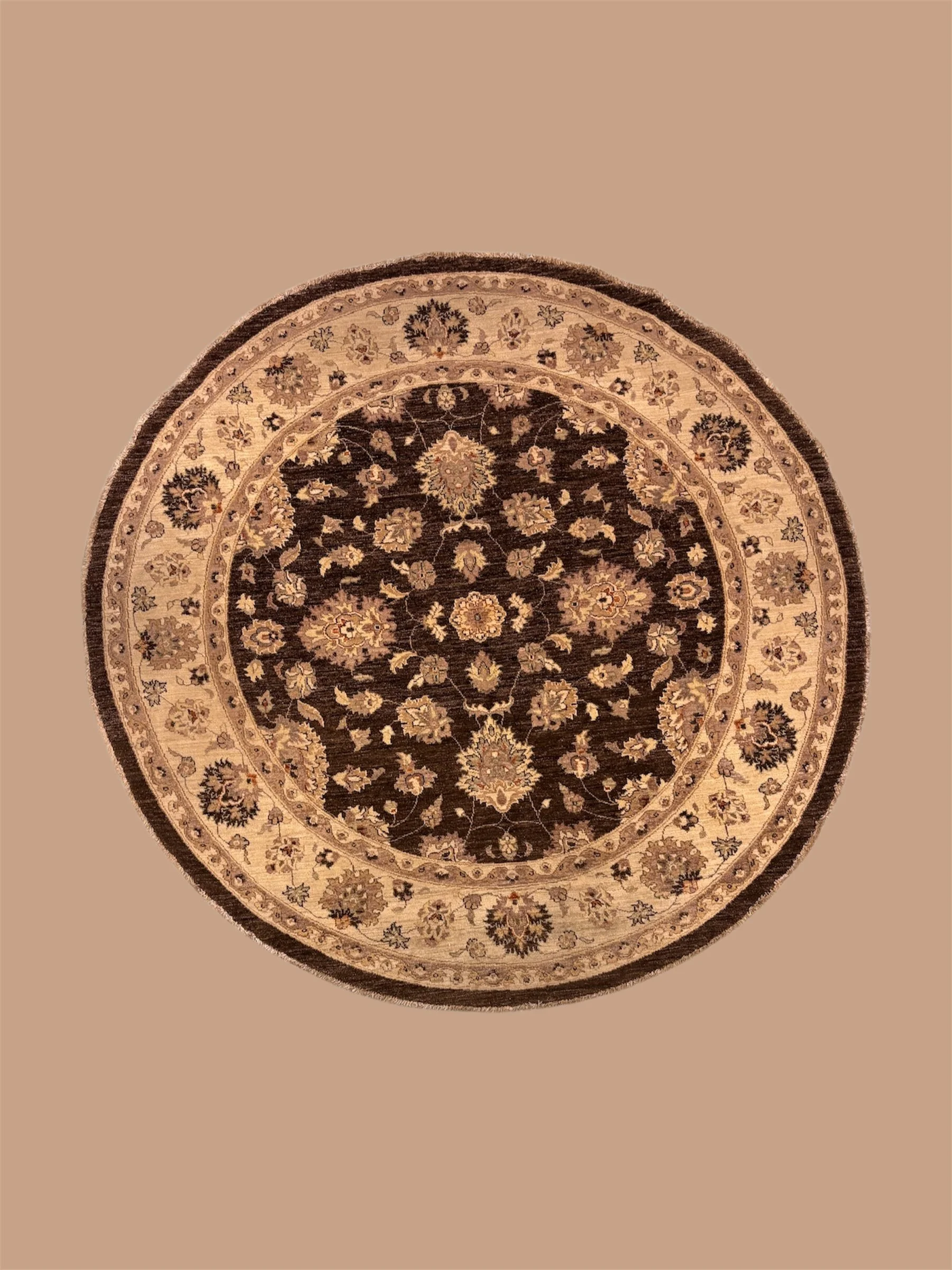 A circular Persian-style rug with intricate floral and geometric patterns in dark and light colors, placed on a beige floor.