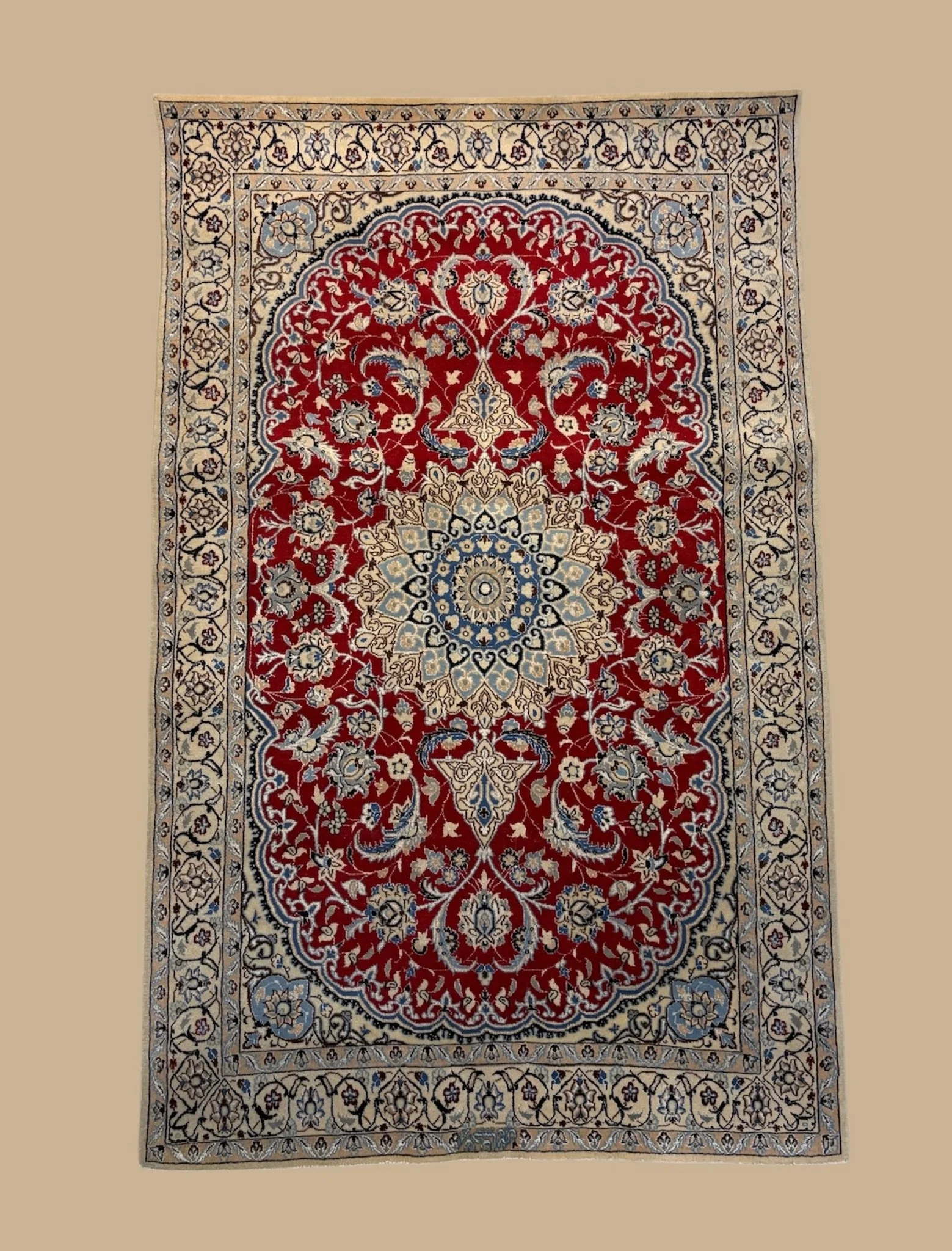 A traditional Persian-style rug with a central medallion, floral motifs, and an ornate border in shades of red, cream, blue, and black.