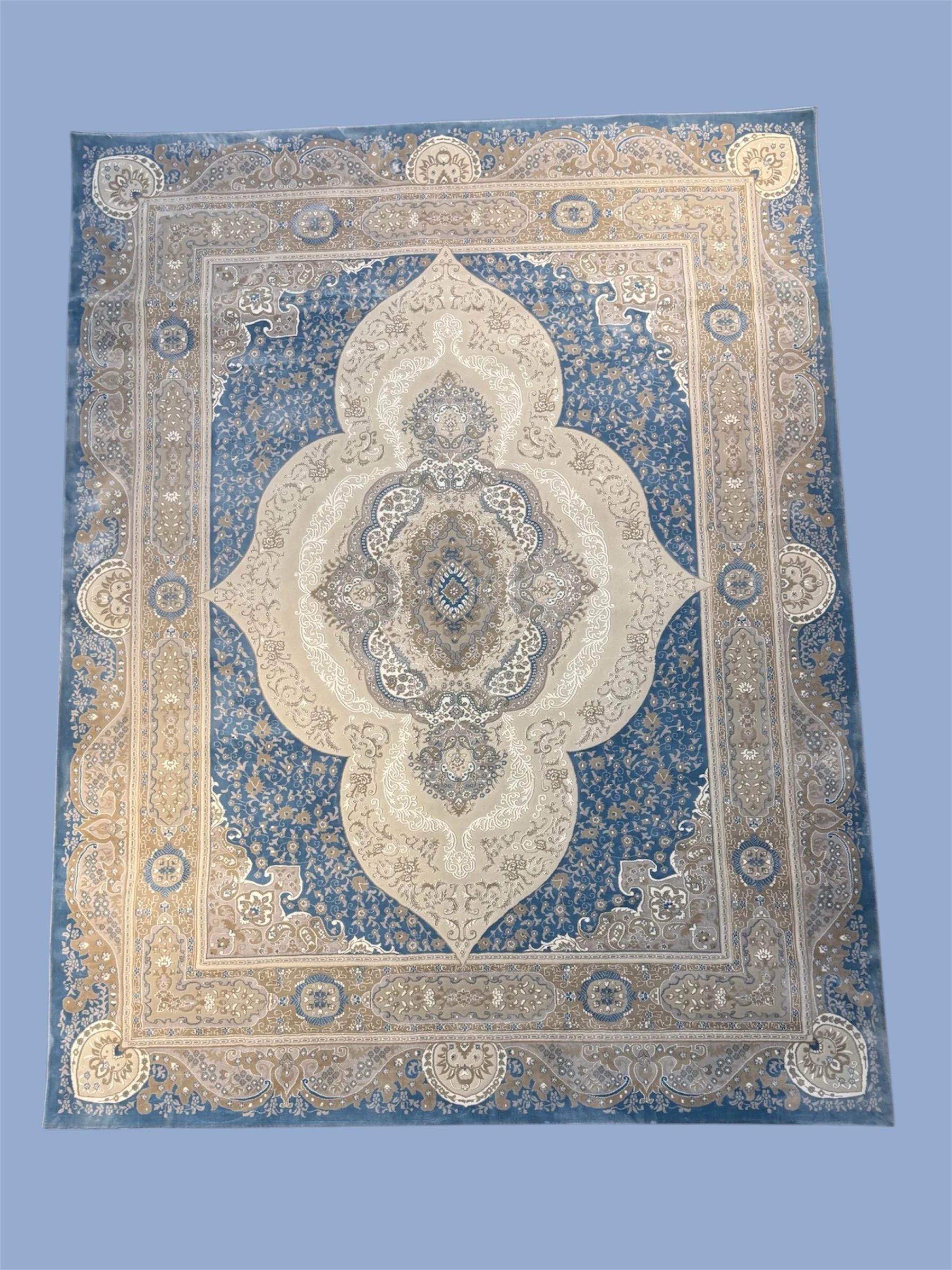 A traditional Persian-style area rug with intricate floral and geometric patterns in shades of blue, beige, and ivory.