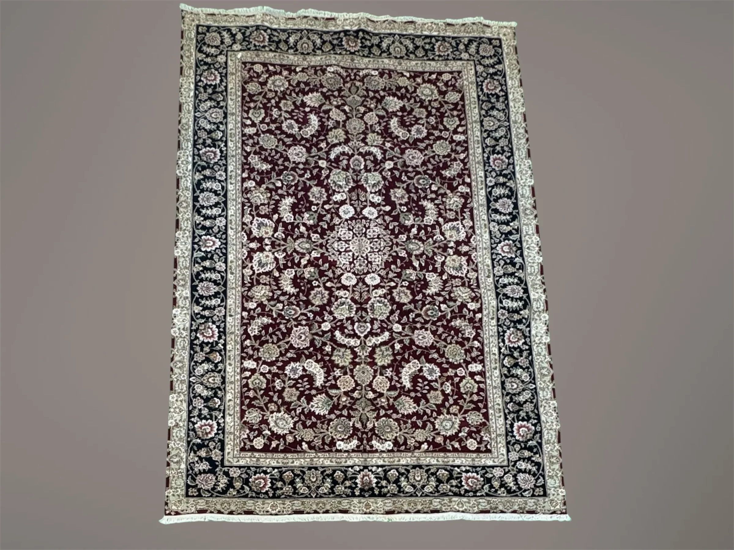 A traditional Persian-style area rug with a deep red background, intricate floral patterns, and a decorative border in shades of black, white, and beige.