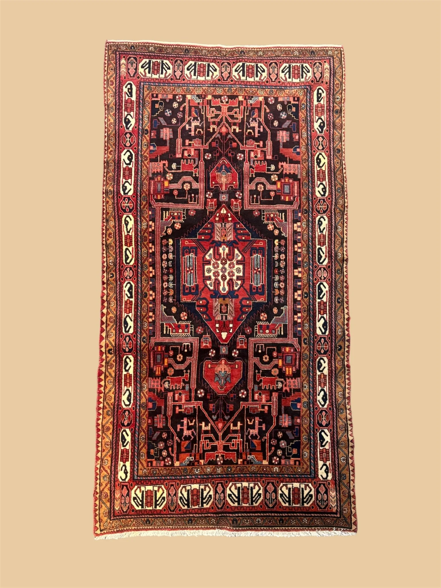 A traditional handwoven Persian rug with intricate geometric patterns and floral motifs in red, black, cream, and blue colors, displayed on a beige background.