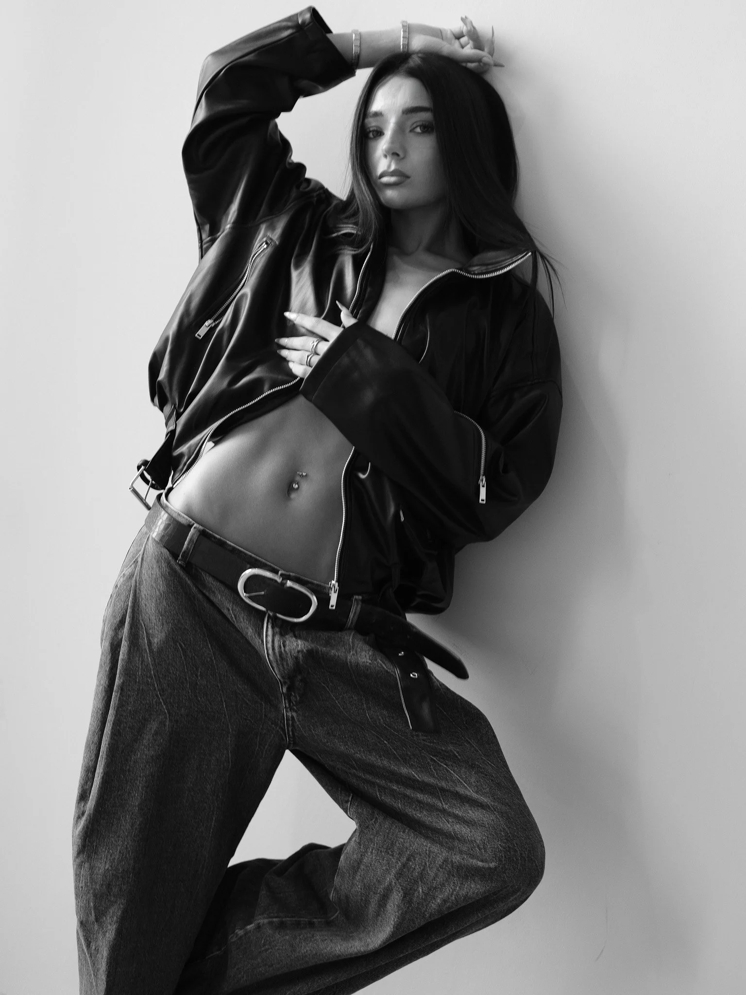 Black-and-white fashion portrait of a model in a leather jacket and jeans, photographed by CAMR Visuals