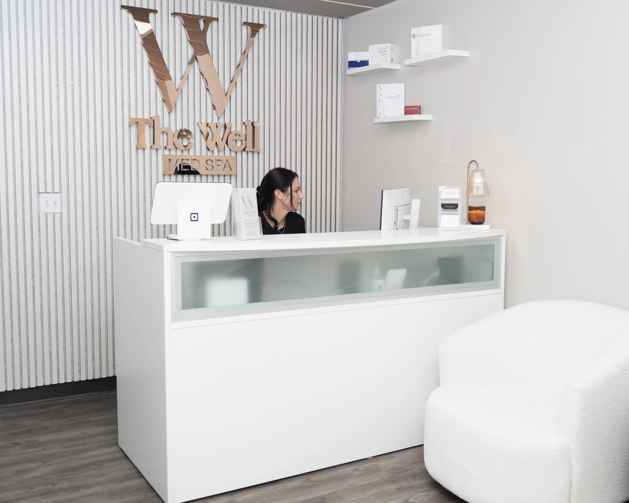 A person using a dropper to apply oil or serum onto their skin.