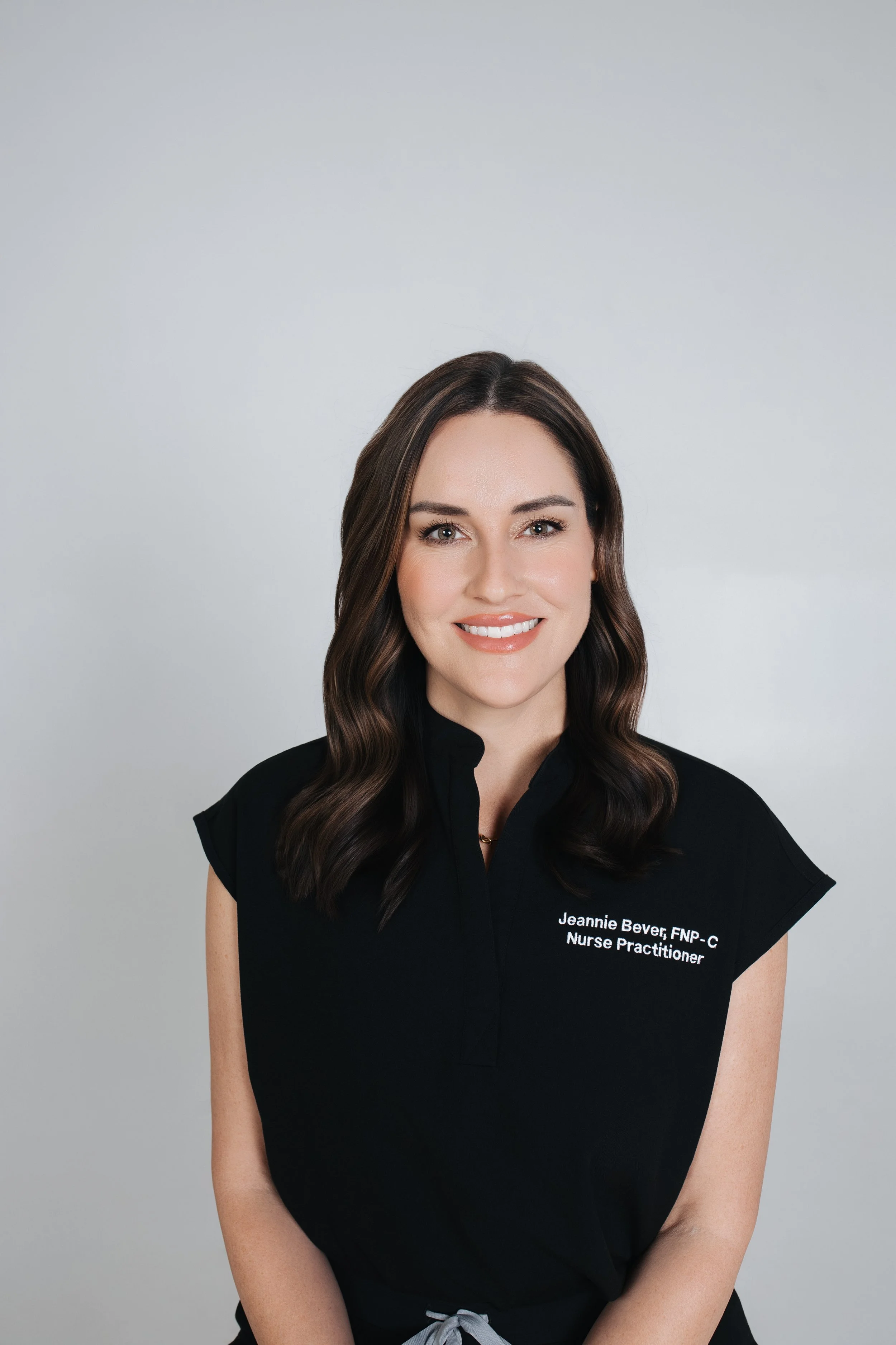 Shadow of a fern on a textured white and black wall with painted scribbles or letters.