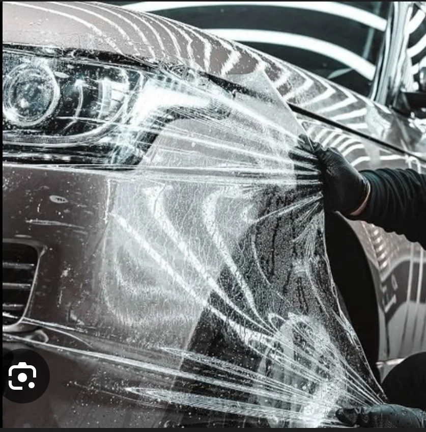 Paint protection film (PPF) installation on vehicle front end providing invisible shield against rock chips and road debris with professional mobile application service