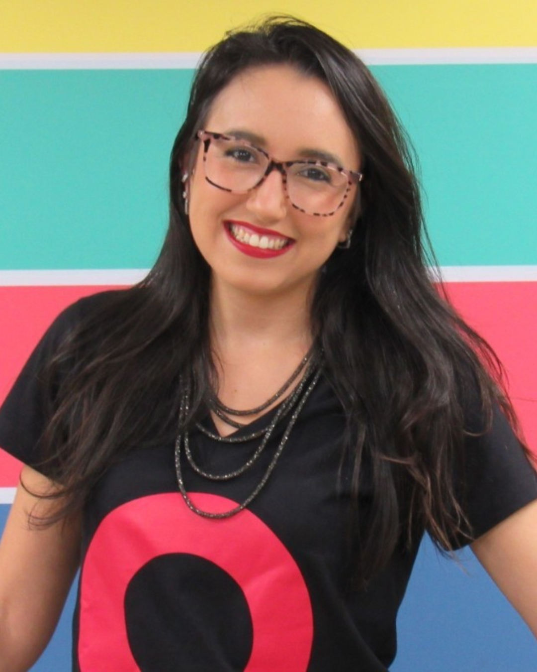 Carolina Ferreguete, COO da Global Touch, mulher sorrindo de cabelos lisos pretos soltos com a blusa da empresa e braços soltos