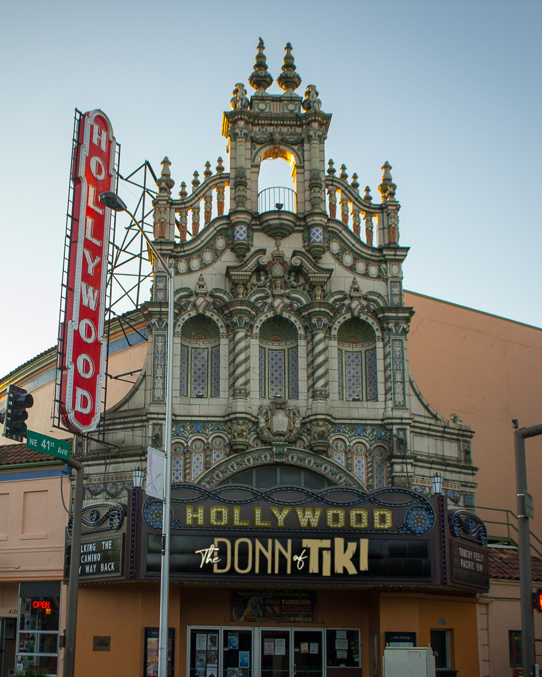 The Hollywood Theatre with ornate architectural details, a marquee sign reading 'The Donn of Tiki,' a vertical 'Hollywood' sign, and street signs at NE 41st Ave in classic Hollywood style.