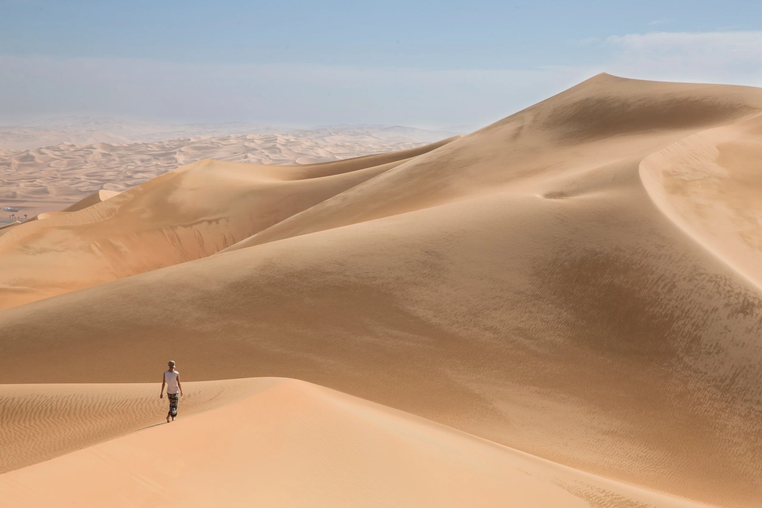 Person walking on sand dunes in a desert