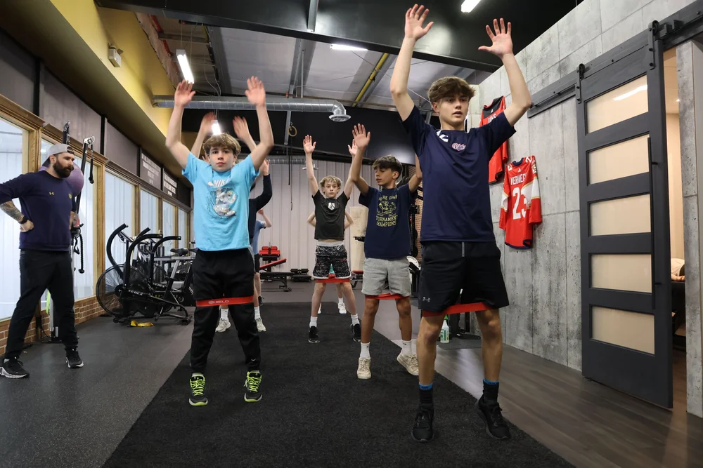 Young athletes performing explosive jumps together