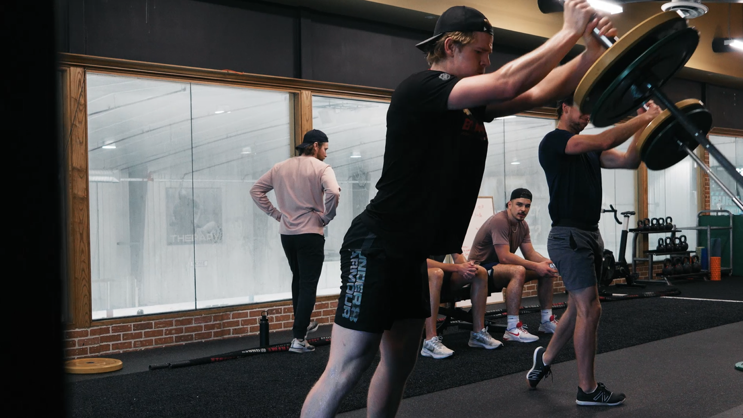 Athletes training with a landmine press at SHIELD