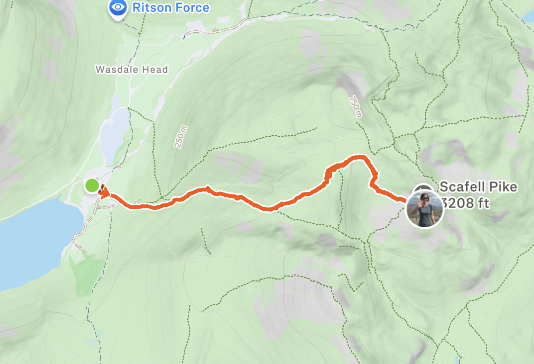Path leading to Scafell Pike, a mountain with an elevation of 3,208 feet, on a green terrain map with hiking trails, indicated by an orange line.