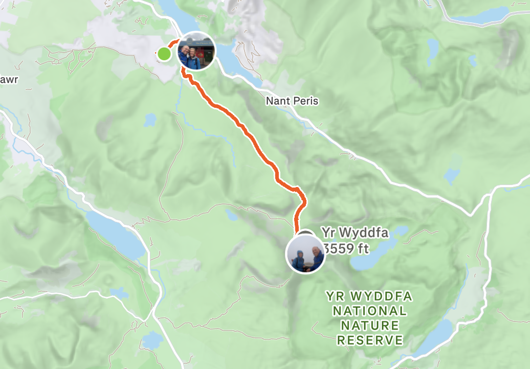 Map showing a hiking trail from a starting point to Yr Wyddfa, also known as Snowdon, with a background of green mountainous terrain and a few lakes, within YR WYDDFA NATIONAL NATURE RESERVE.