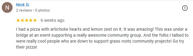 Screenshot of a Google review by Nick D. about a pizza with artichoke hearts and lemon zest, supporting a community event, praising the people involved.
