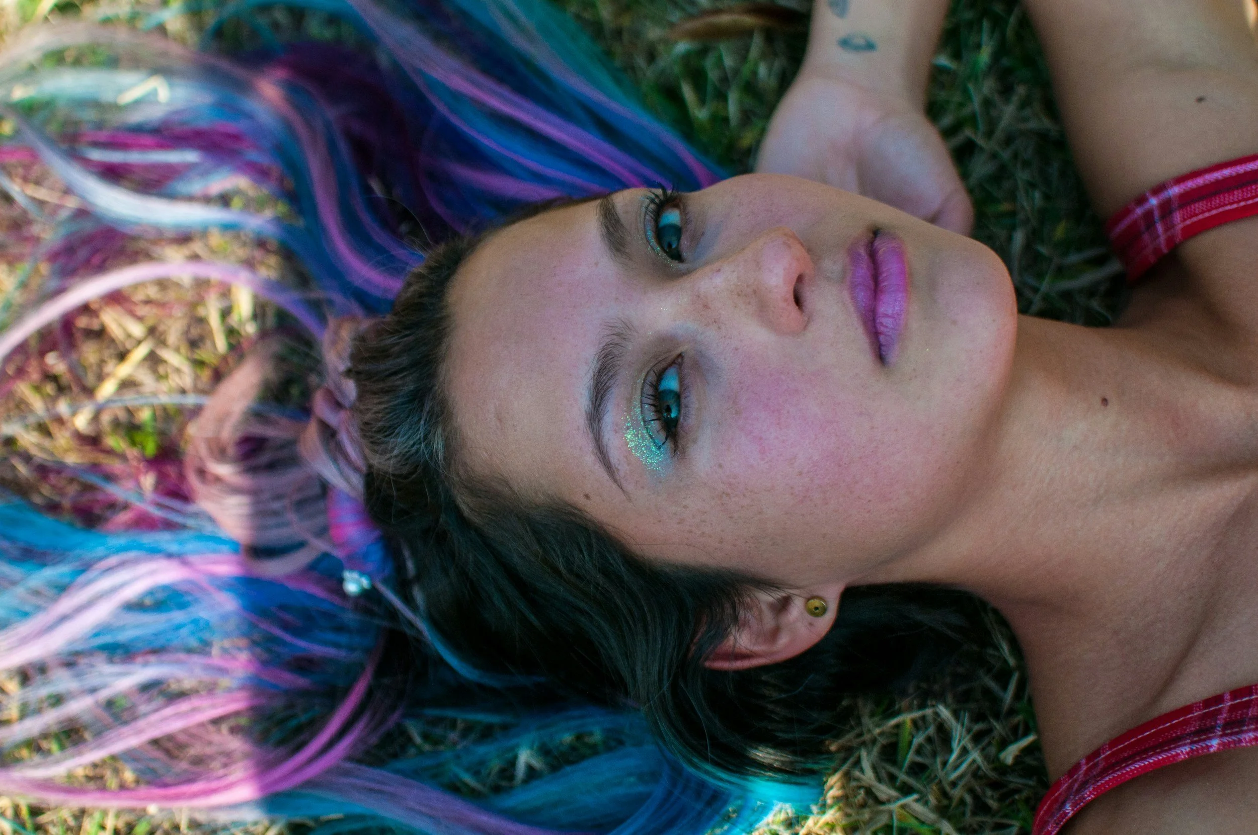 Woman with vibrant purple hair expressing confidence and individuality.