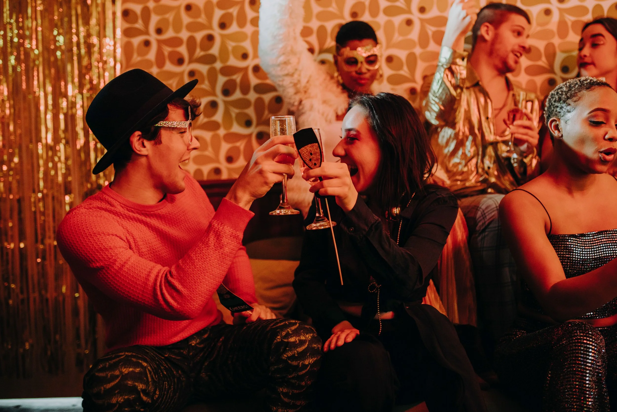 Friends in costumes laughing and socializing at a Halloween party.