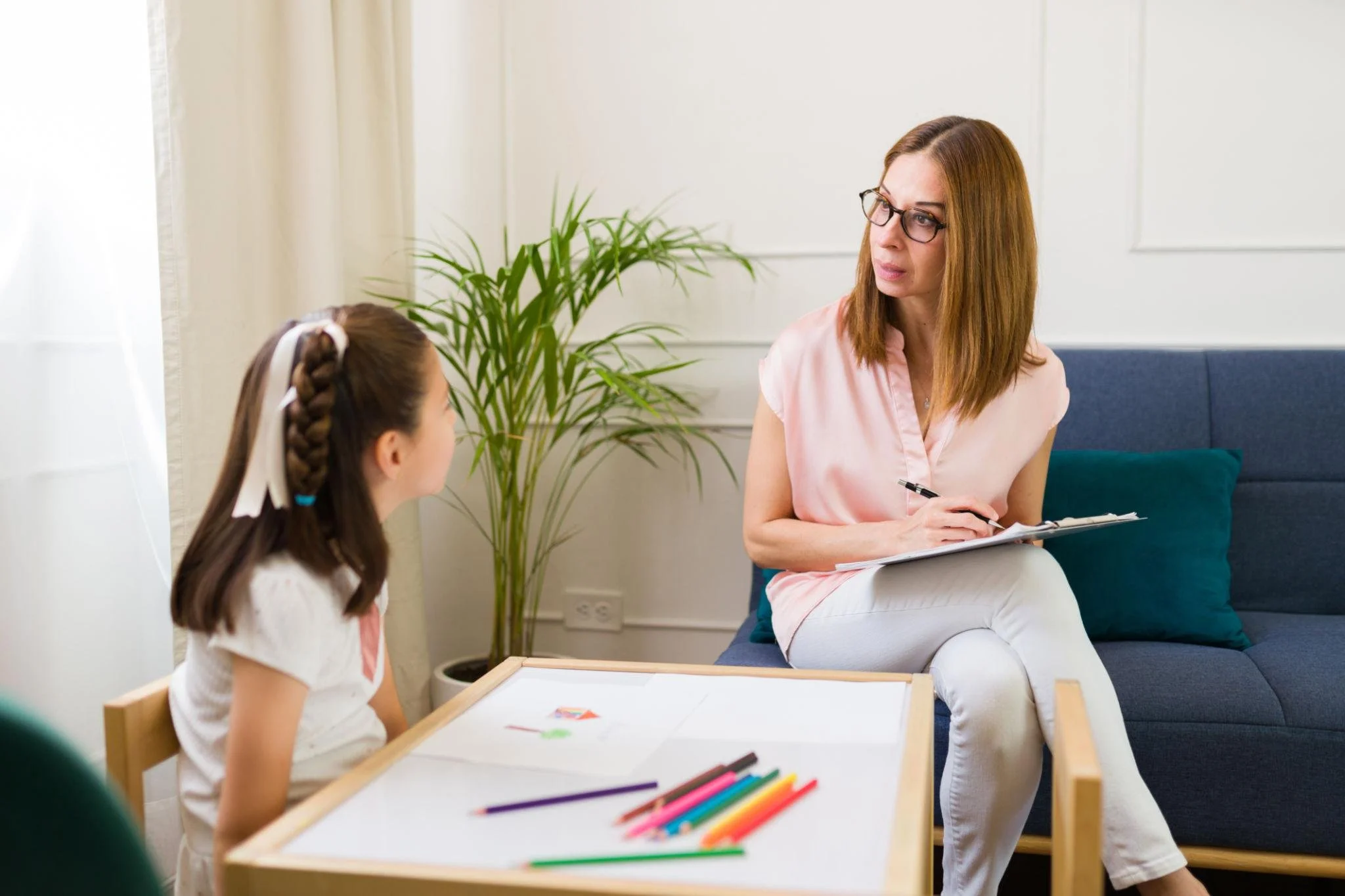 Young girl talking with a female therapist during a child counseling session in Arizona focused on emotional wellness and mental health support.