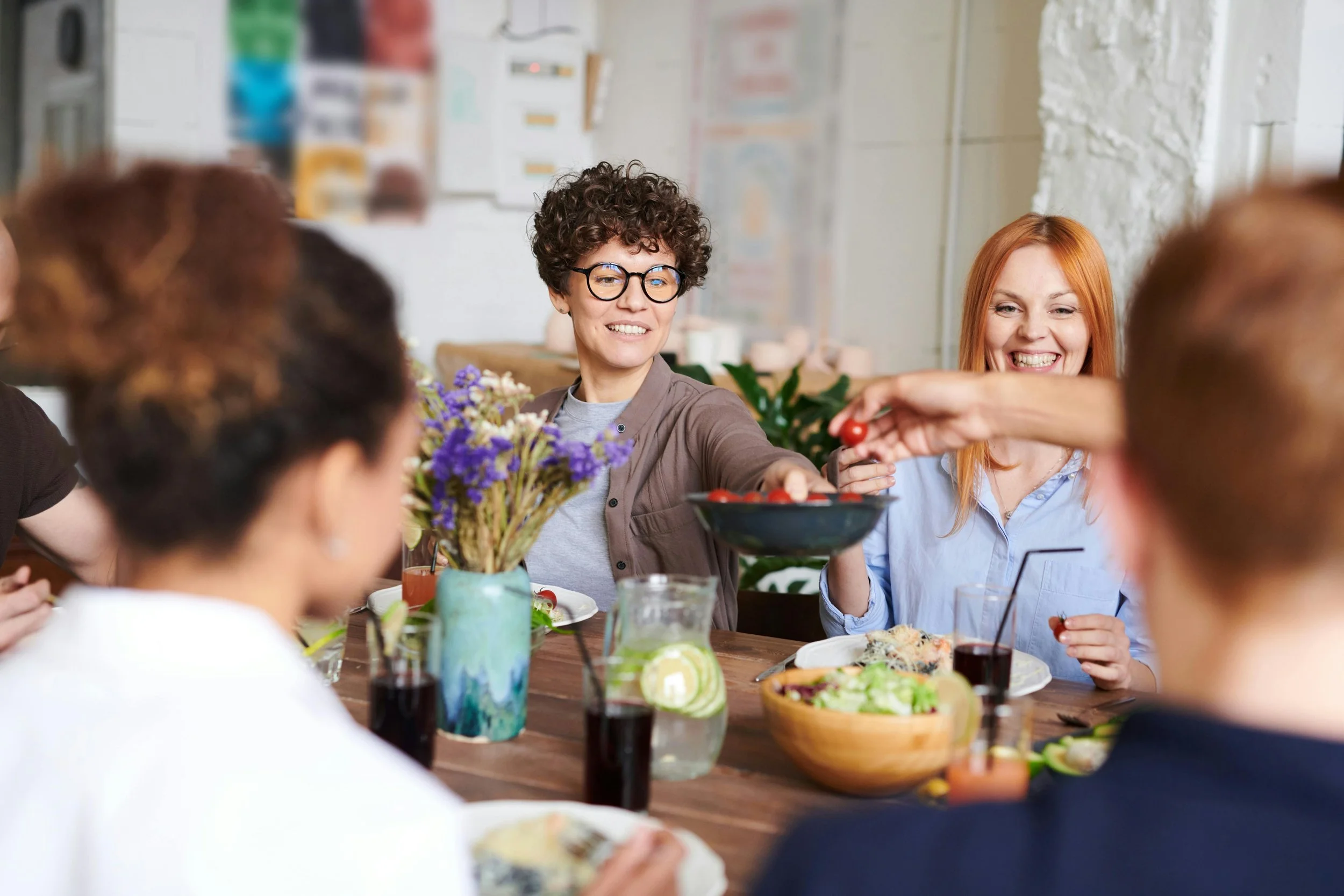 Woman smiling while eating with friends, showing life after trauma therapy