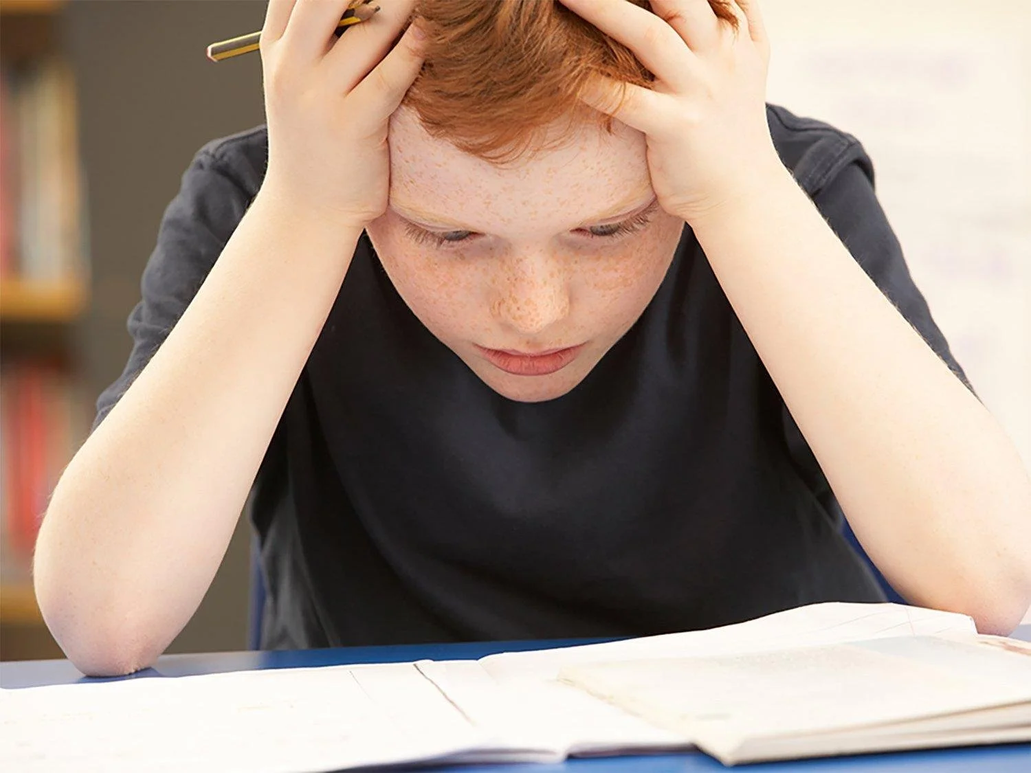 Child sitting quietly and looking thoughtful during a mental health counseling session for anxiety and emotional wellness.