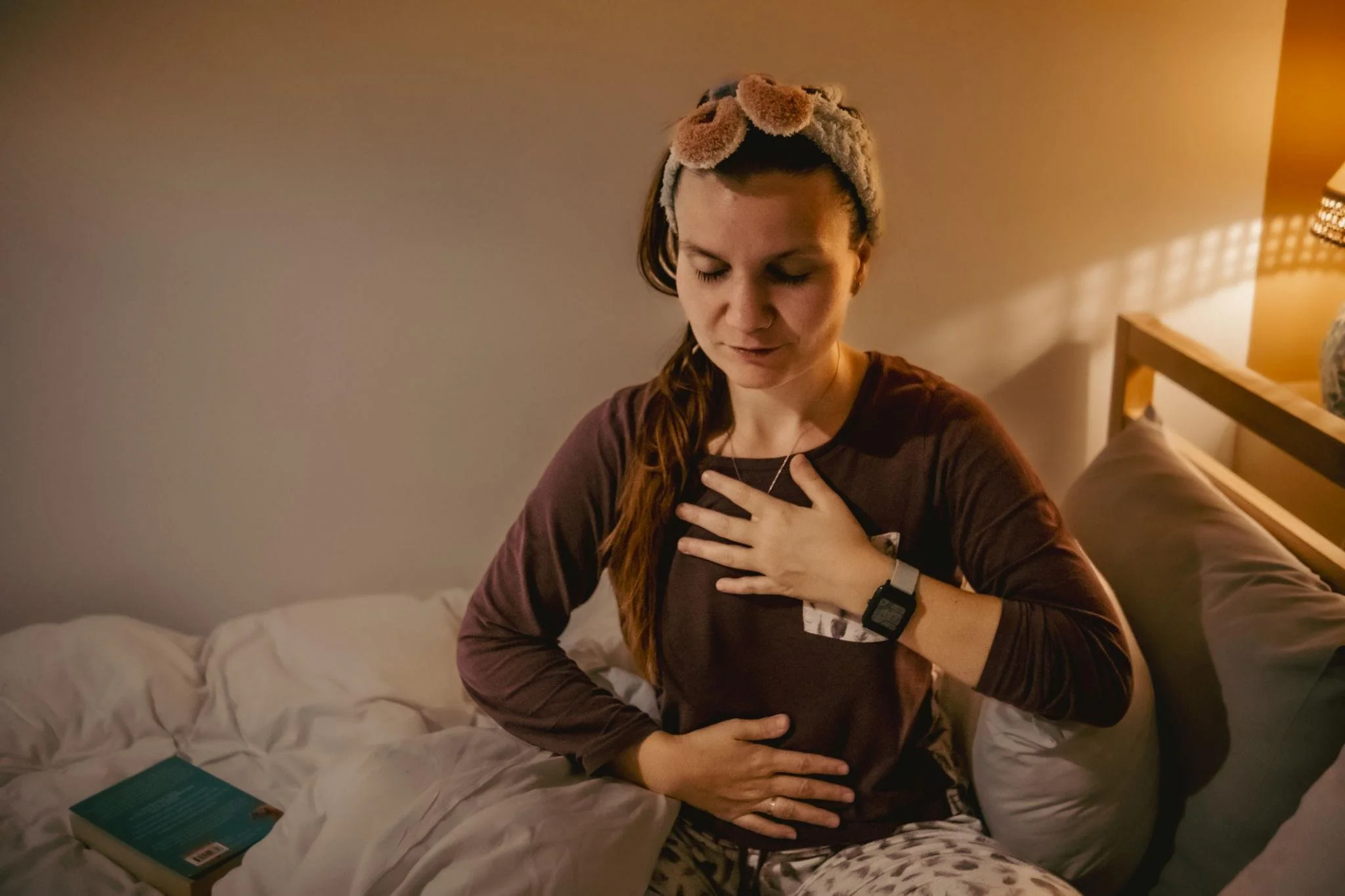 Woman meditating before bed to manage anxiety and racing thoughts at night.