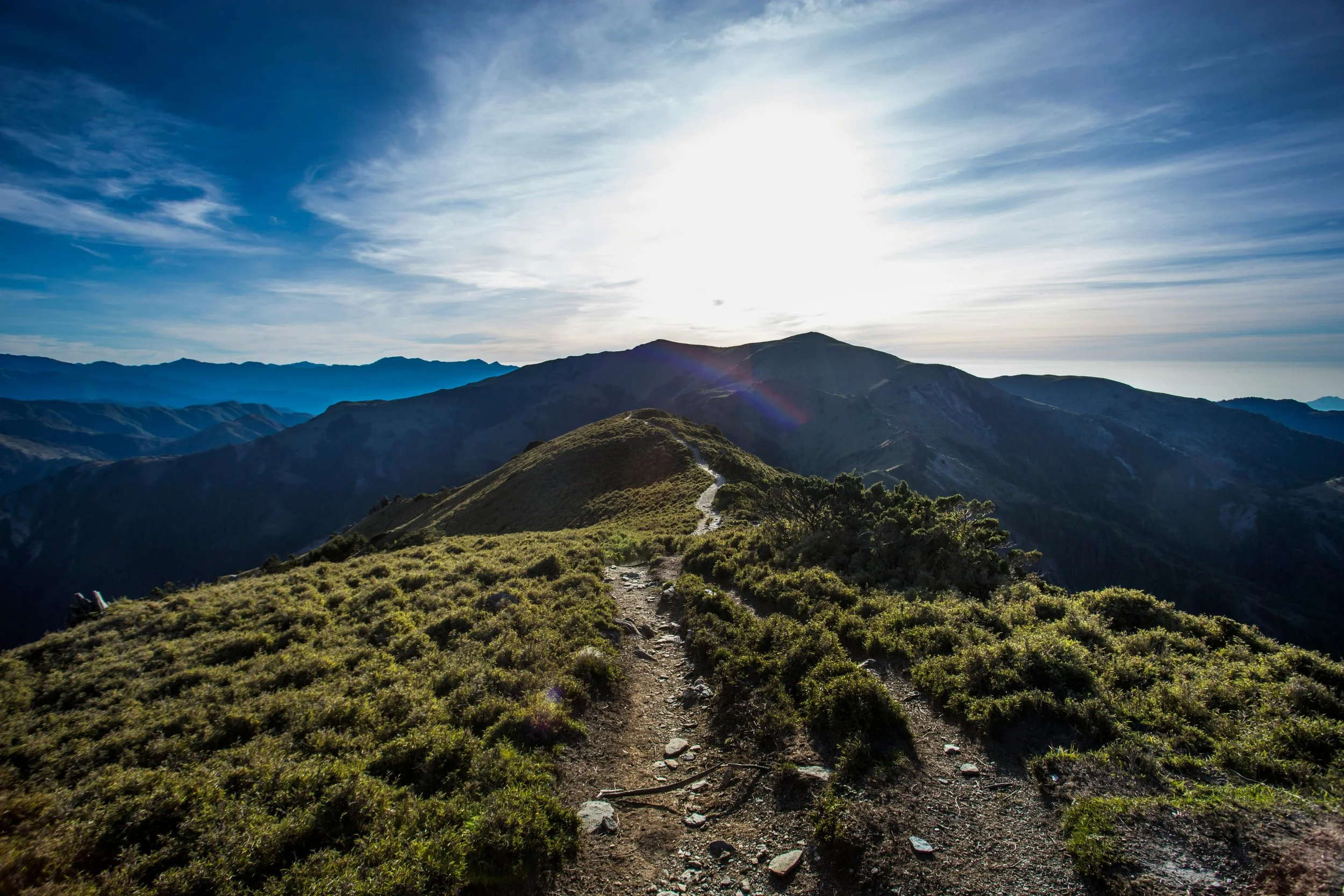 Sunlight breaking over mountains with a winding path, symbolizing hope, growth, and the journey toward mental health wellness and counseling in Arizona.